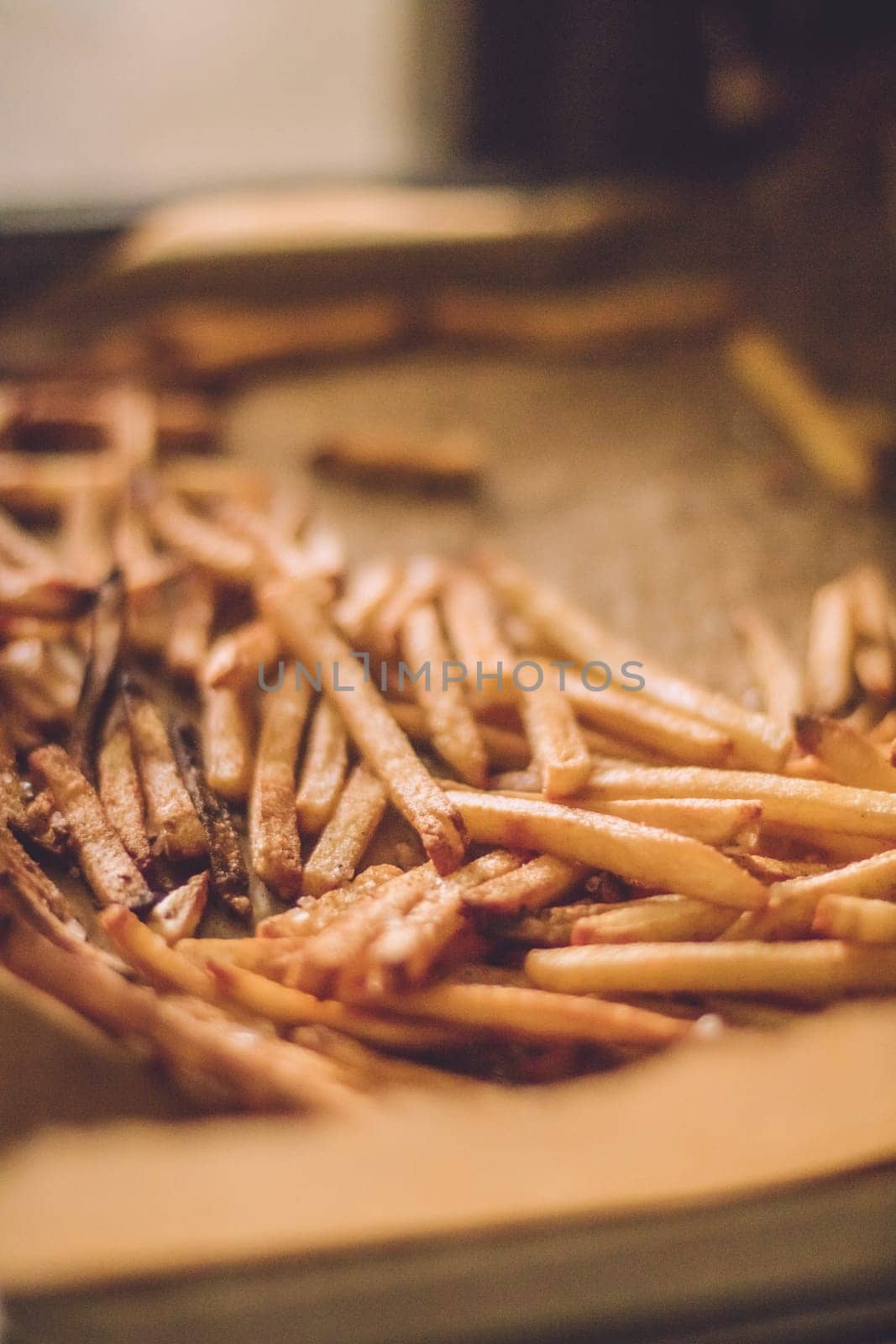 just cooked french fries in the oven - rustic food and homemade cooking styled concept by Anneleven