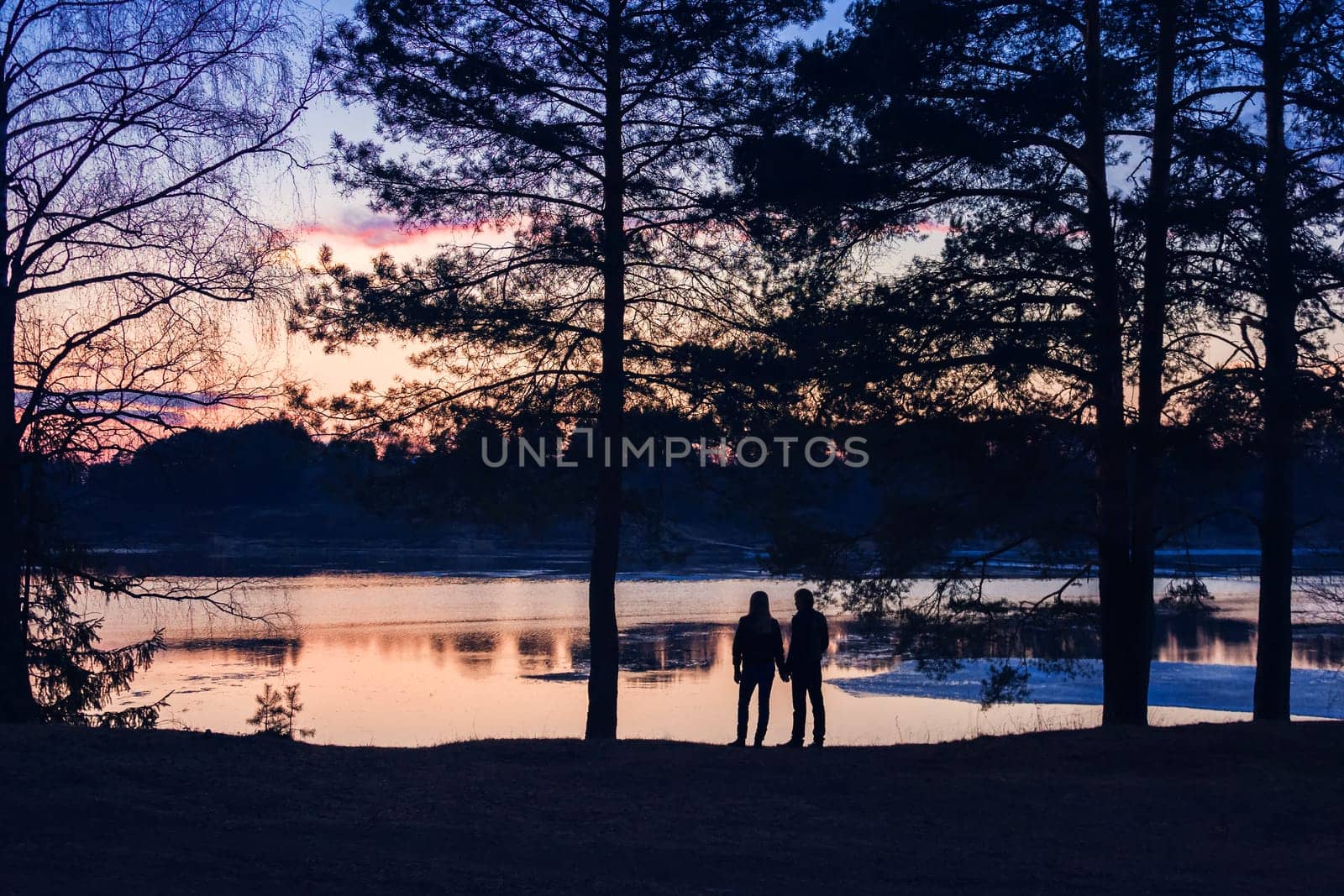 silhouette couple at sunset in the summer at the river