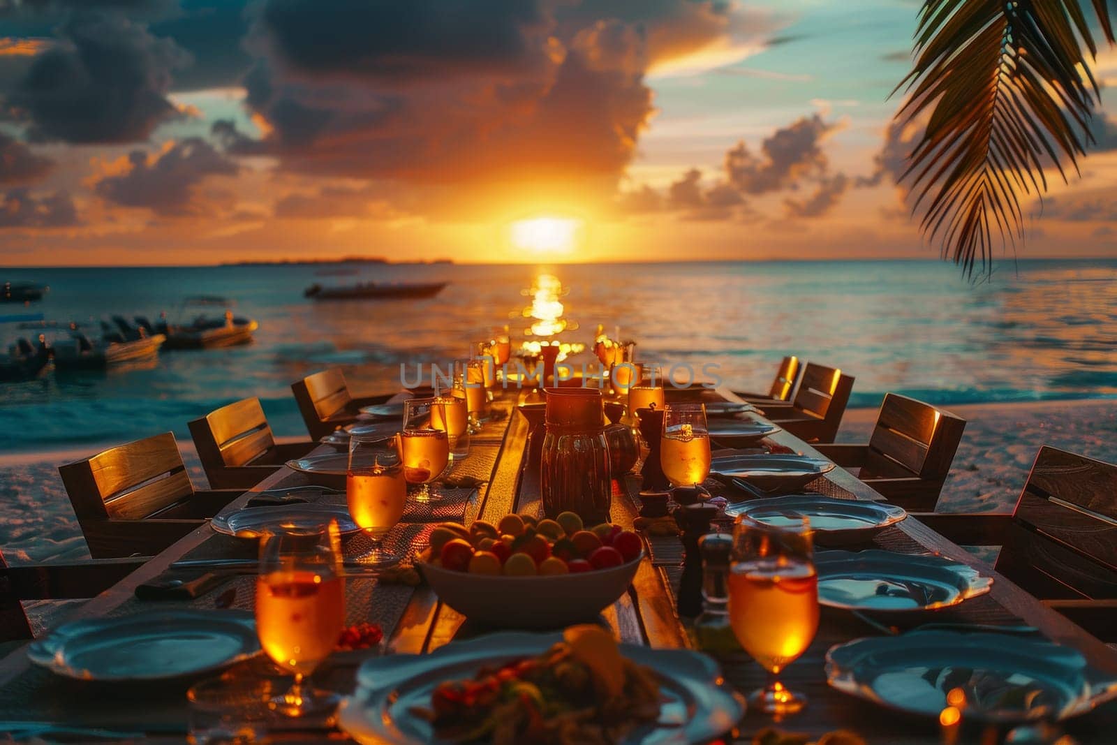 A long table with a beautiful ocean view in the background. The table is set with plates, glasses, and utensils, and there are several chairs around it. The atmosphere is relaxed and inviting