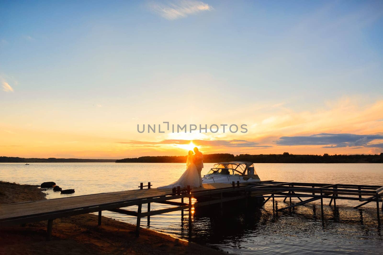 Bride and groom embracing at sunset, silhouette