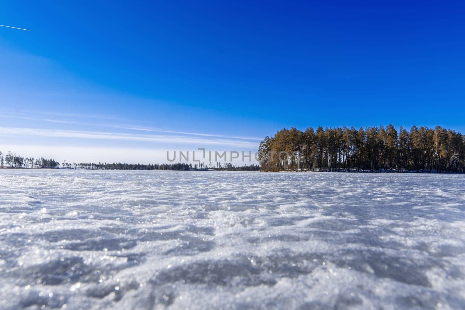 blue clear sky over the lake covered by ice in winter
