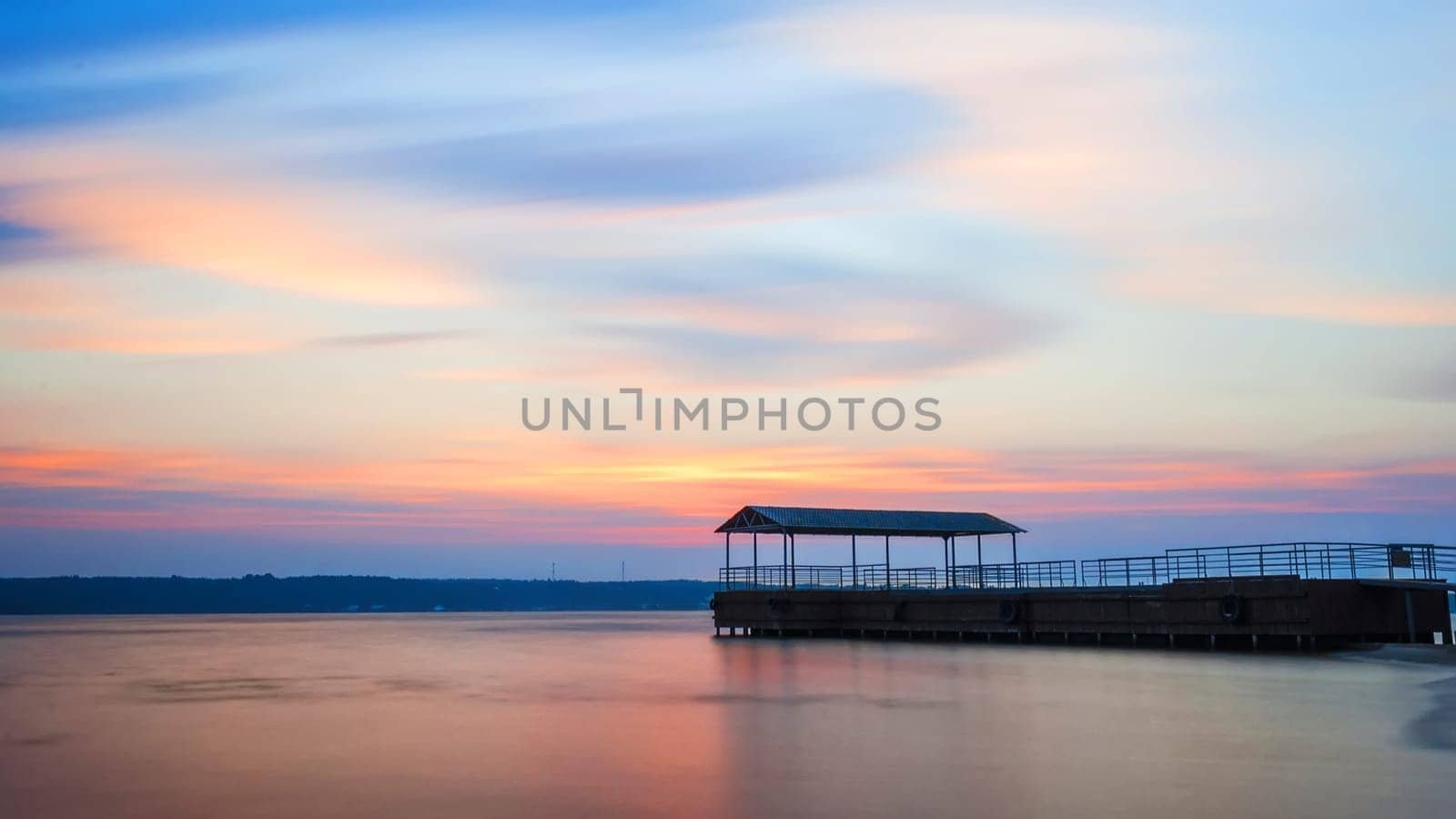 pier in the water under a pink-blue sky on long exposures