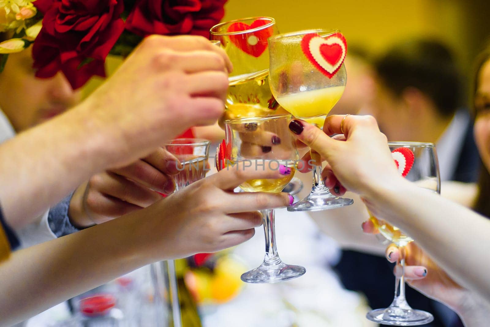 toast a glass of wine in the hands of a group of people celebrating the holiday
