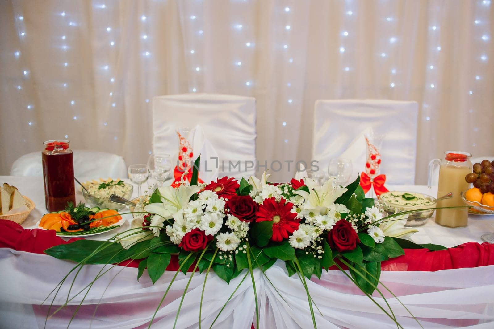 table is decorated with artificial flowers, food and drinks in the restaurant
