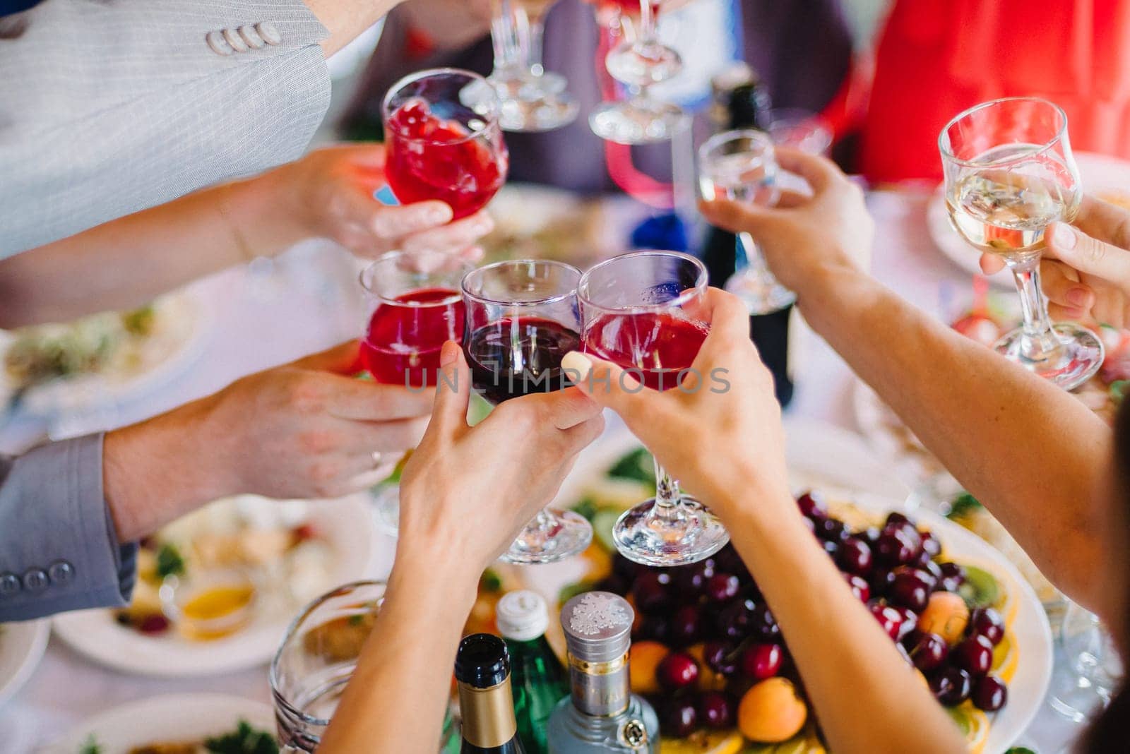 wine glasses in the hands of a group of people on a happy party celebrating the holiday