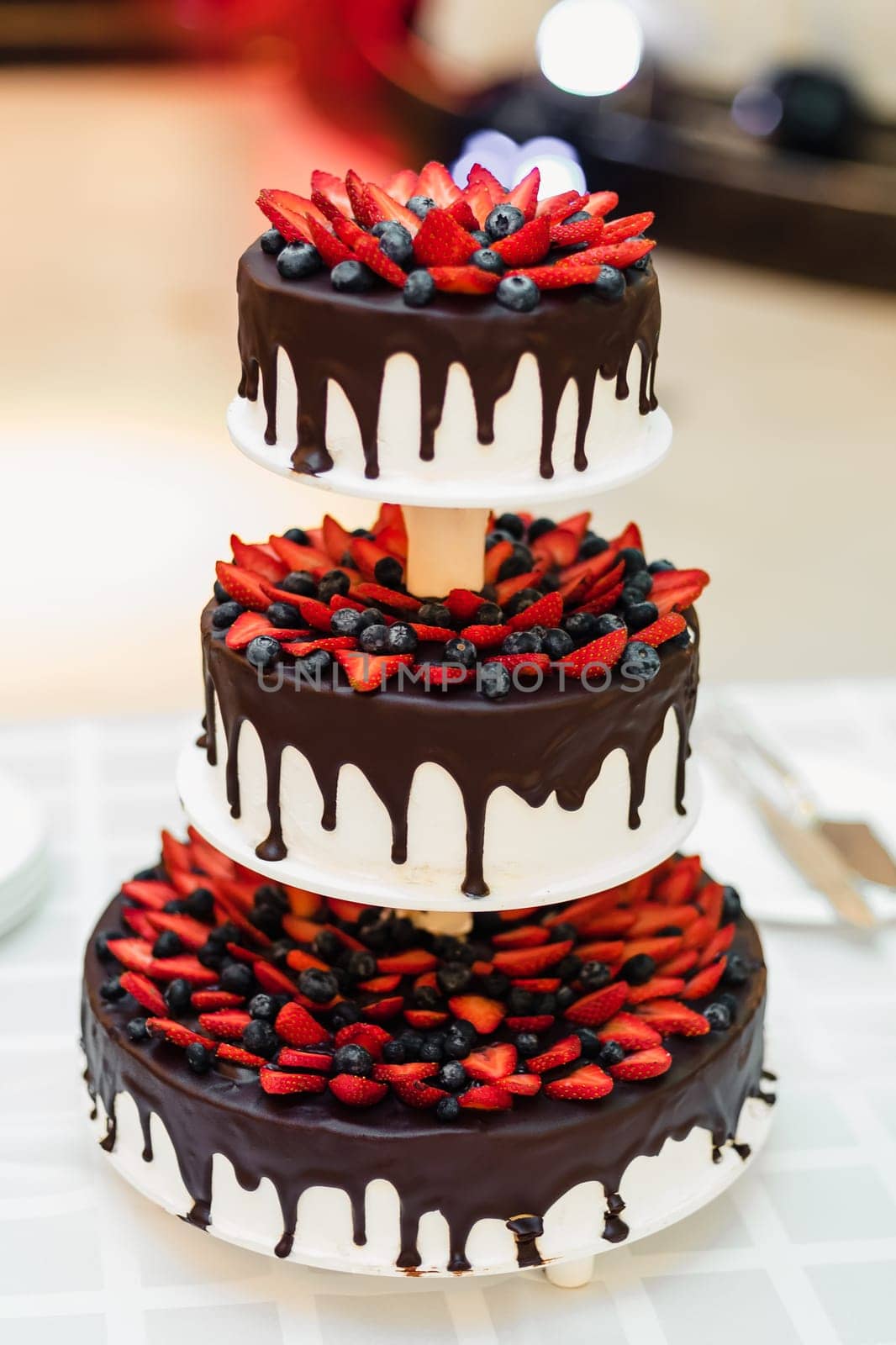 birthday cake in chocolate glaze with strawberry and bilberry berries at the festival