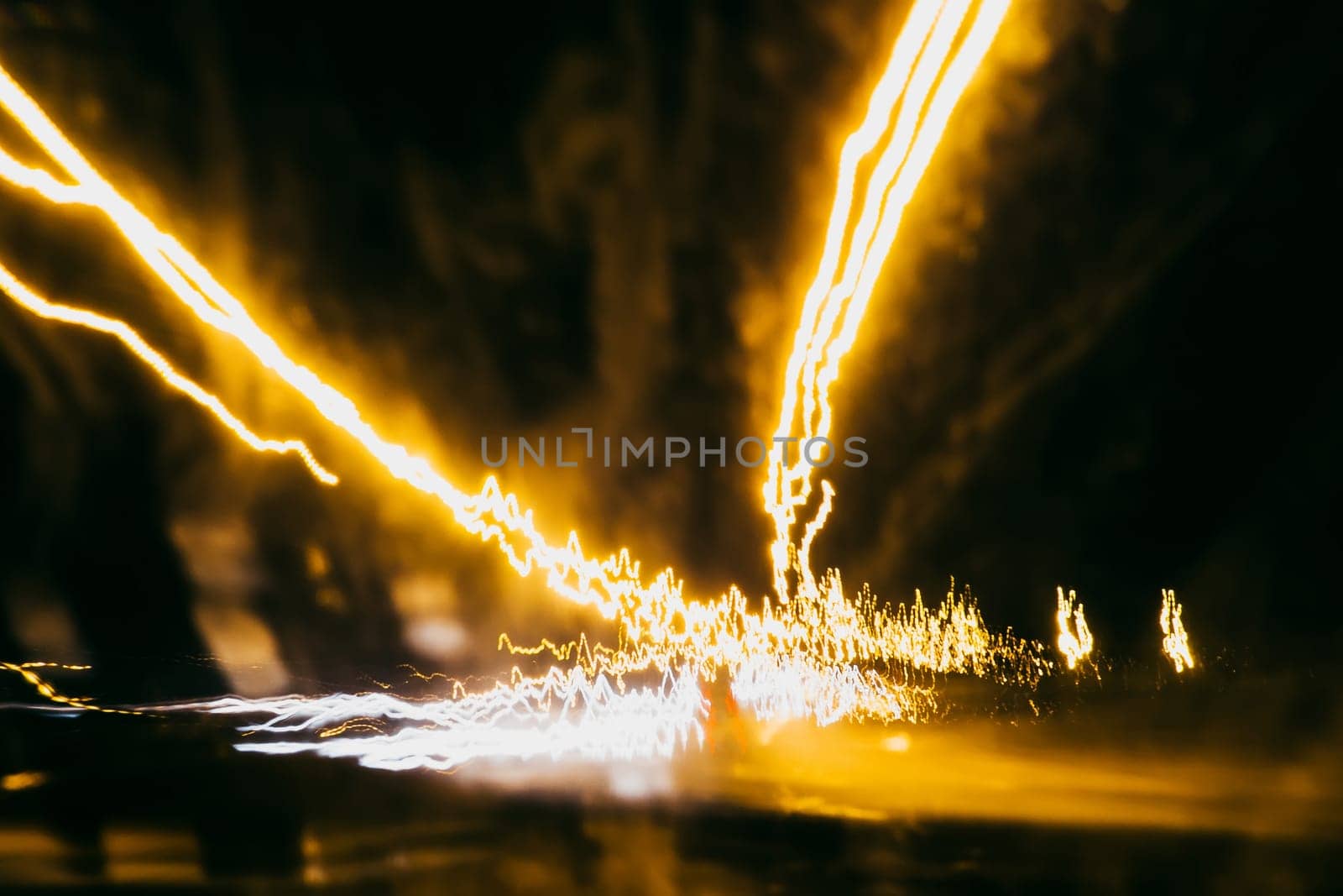 blurred abstract traces of bright night lights on the road