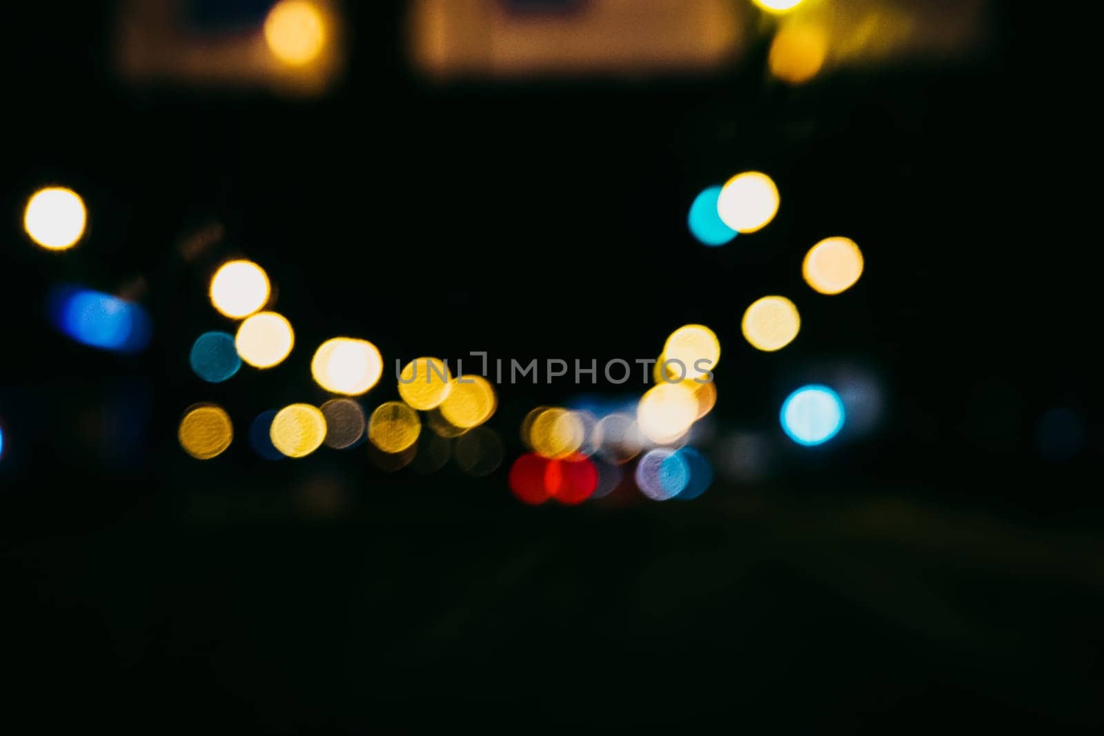 blurred city lights and lanterns in the shape of bokeh through the glass of the car on the road