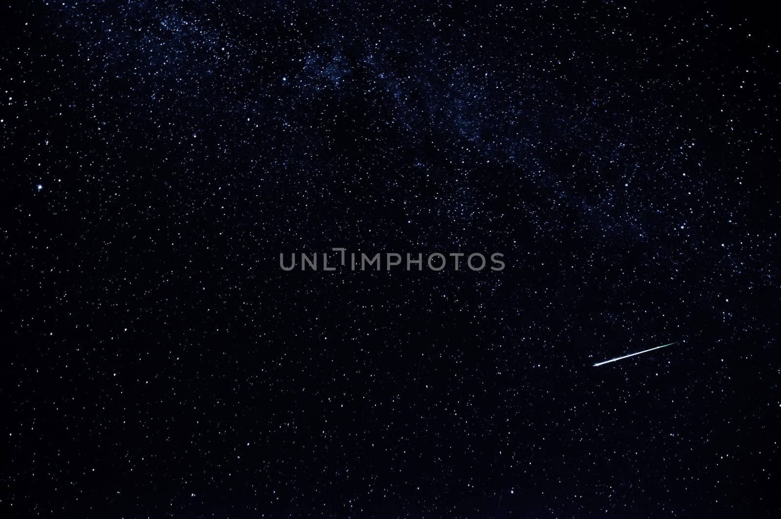 dark starry sky with falling star and the milky way on a black background