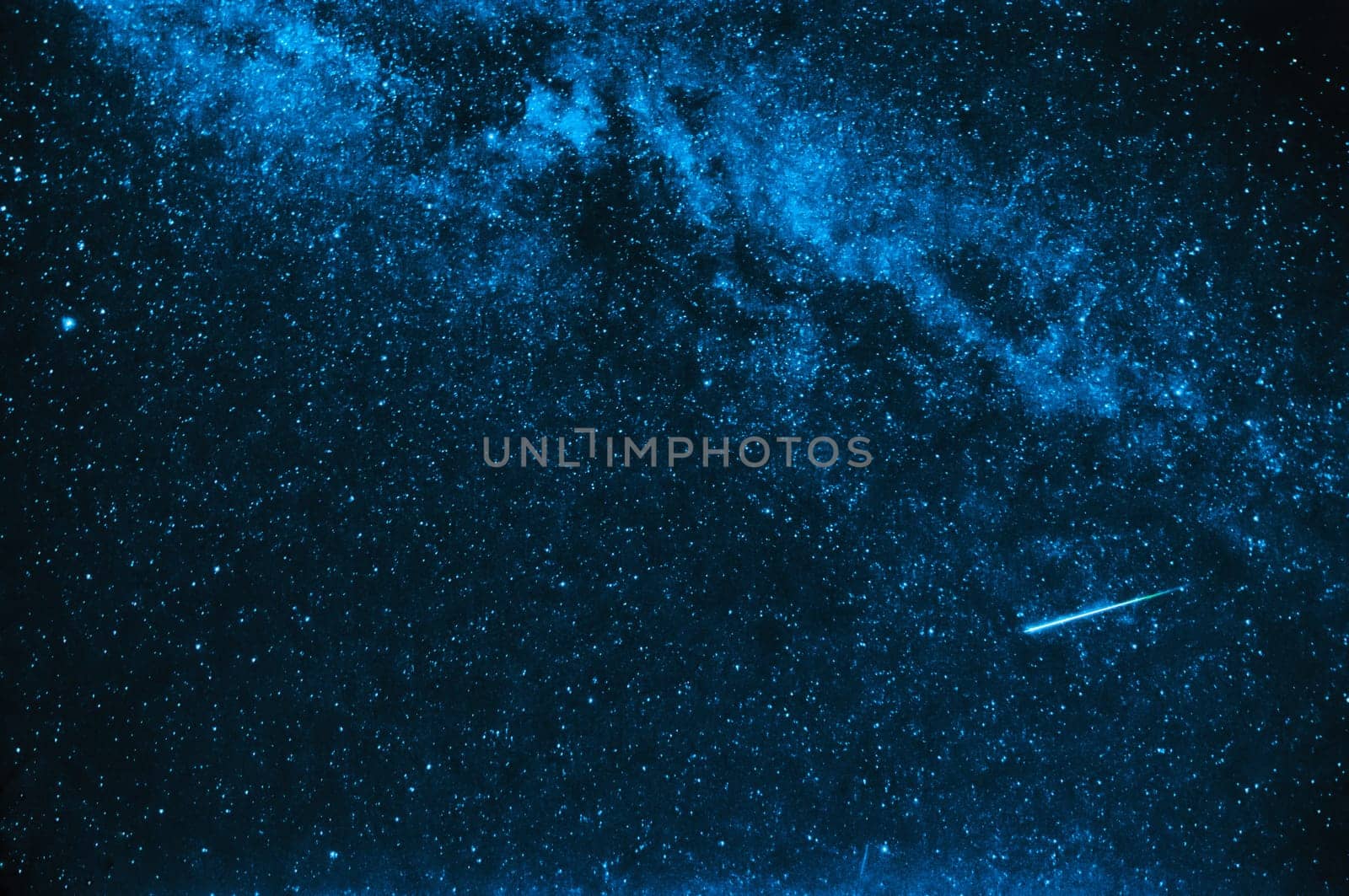 falling star on a background of blue sky with the milky way