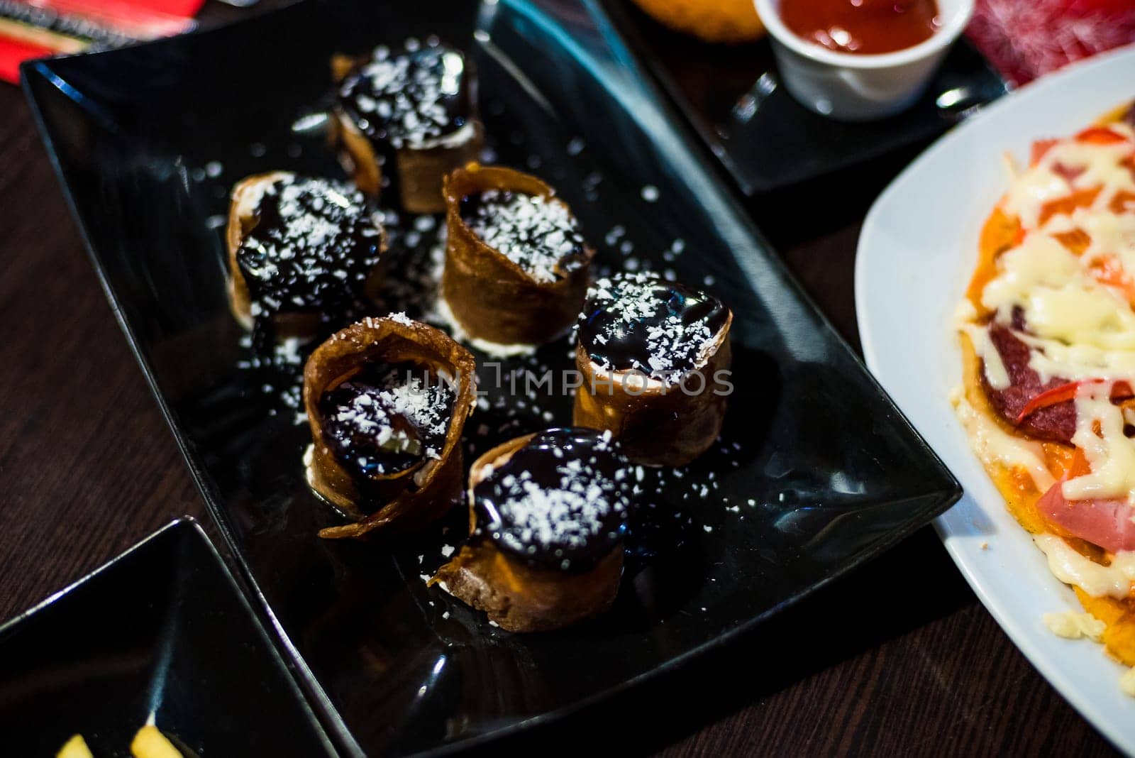 sweet rolls with topping for a delicious dessert on black plate