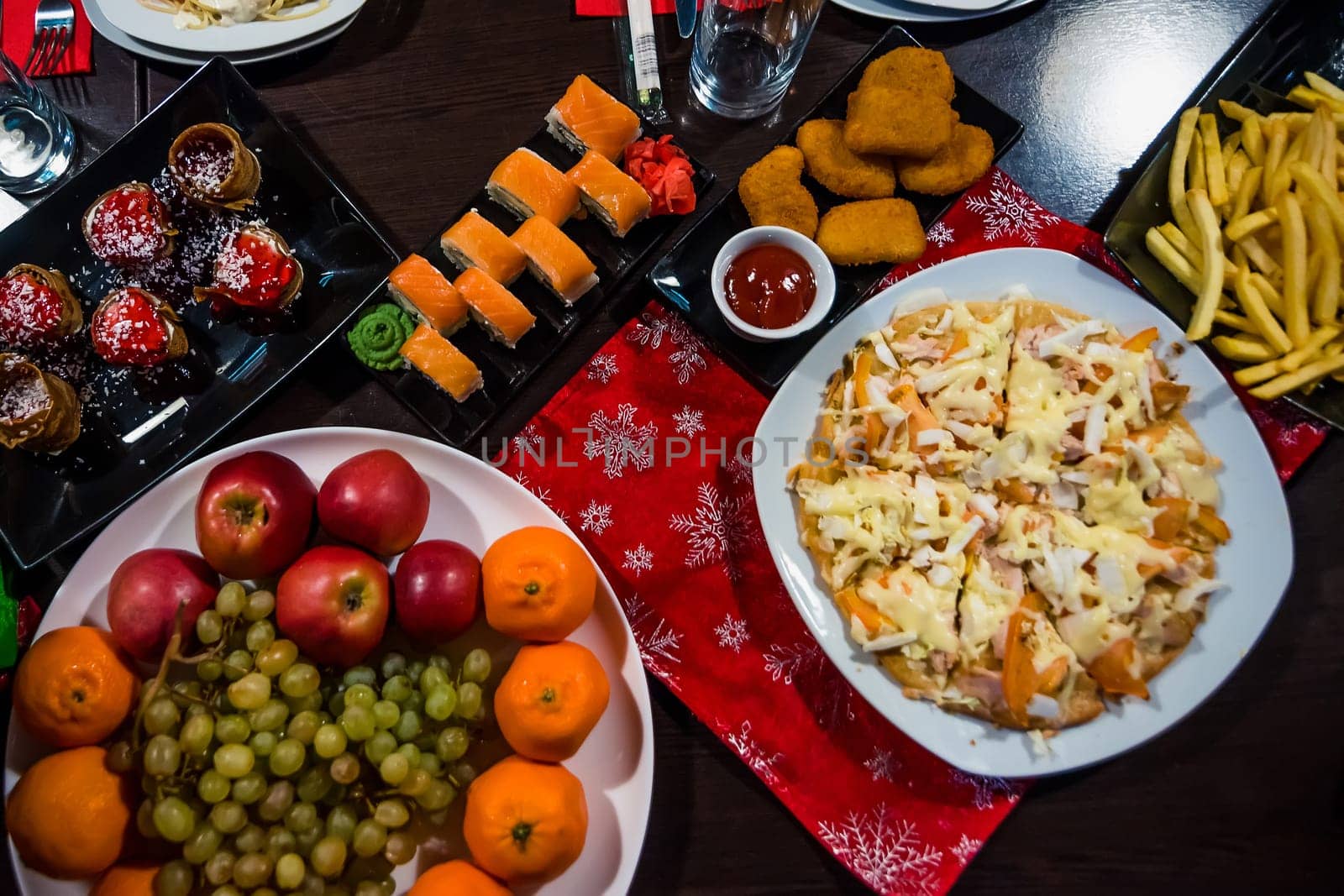 rolls, pizza, baked chicken, fruit and many other foods on the table in a cafe