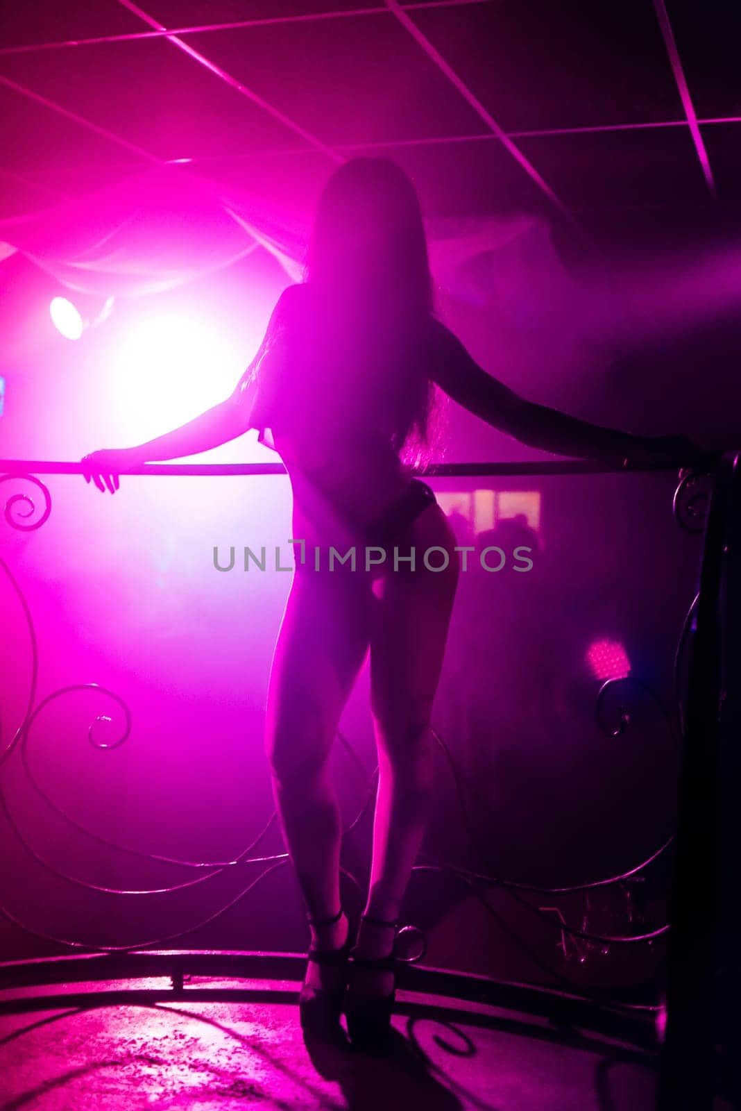 young girl with svelte hot body posing on the dance floor with a naked body in a nightclub