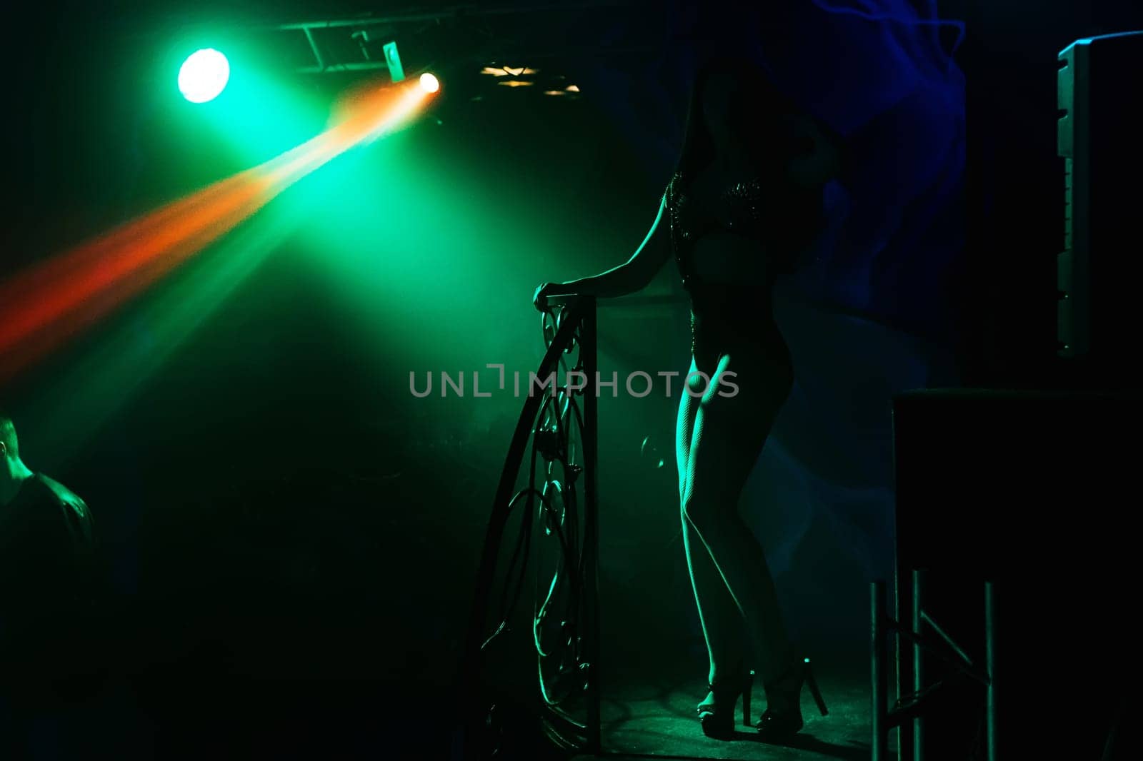 dancer silhouette with shapely long legs in a nightclub on stage
