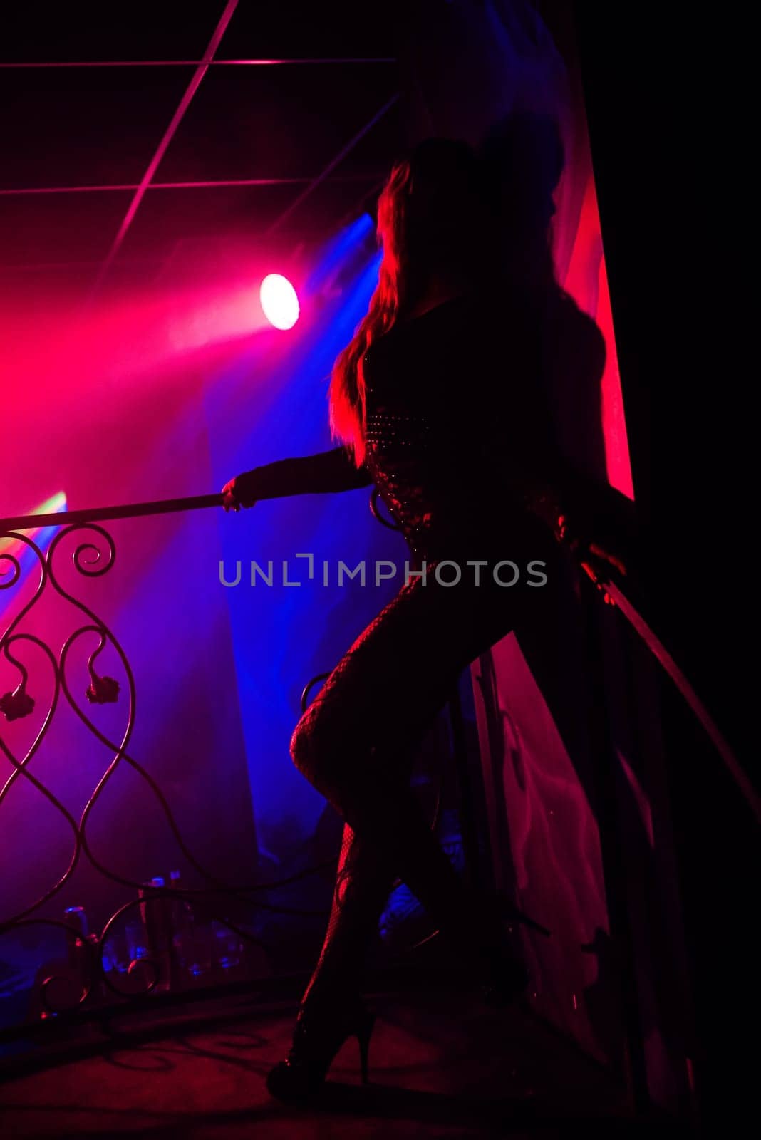 girl posing at a wall in a nightclub on stage silhouette with red backlight