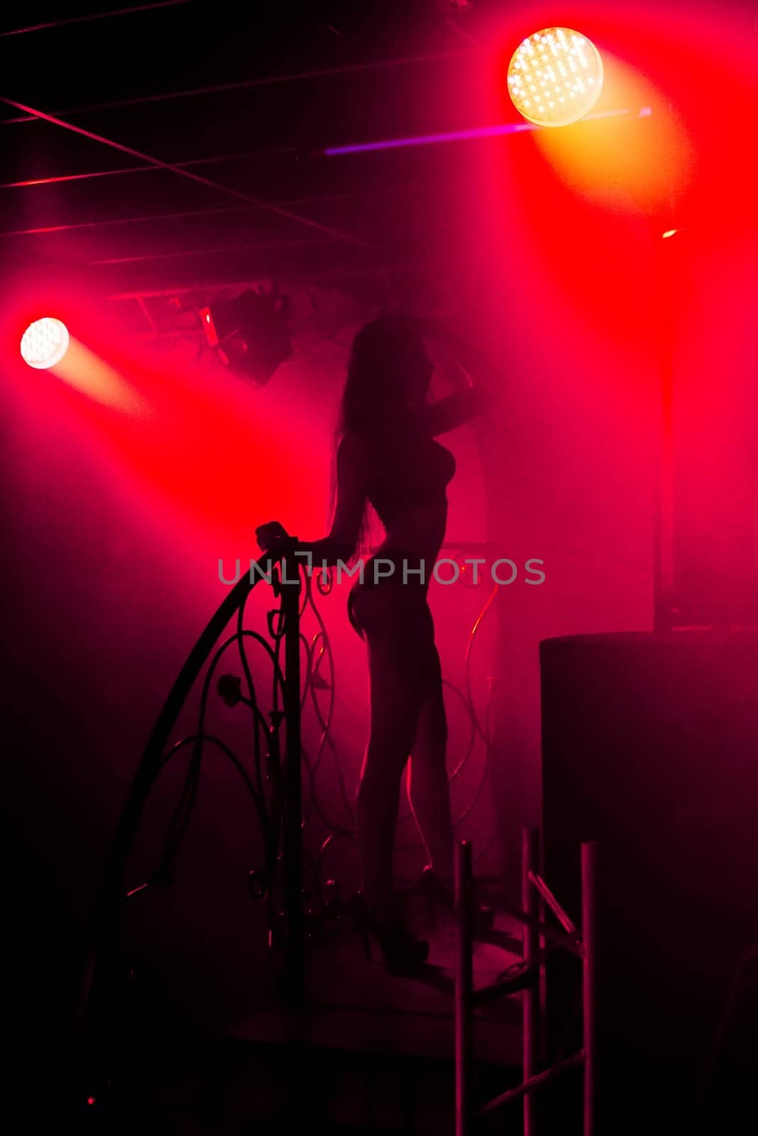 slender young girl with sexy slim figure on the stage in the club at the event
