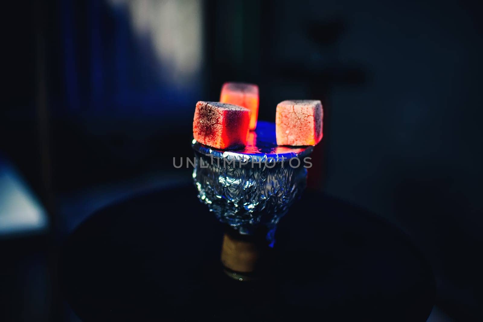 bowl of hookah tobacco for Smoking with hot coals on the foil on a dark background for a traditional Asian holiday