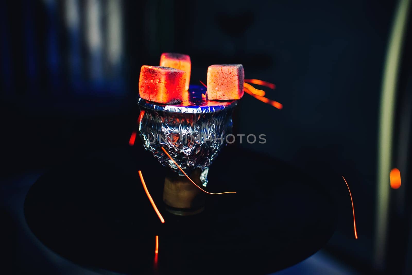 hot coals on the foil on the bowl of the hookah tobacco Smoking on dark background