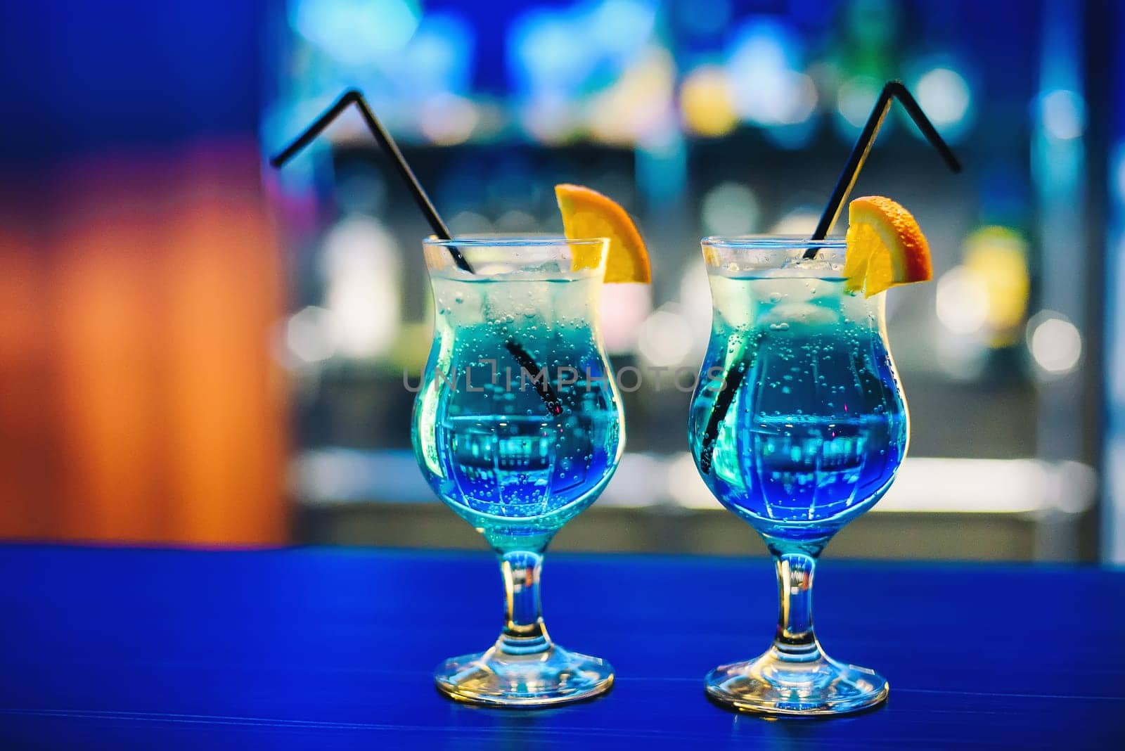blue Martini cocktail in glass with orange on the bar delicious and colorful party guests with alcohol