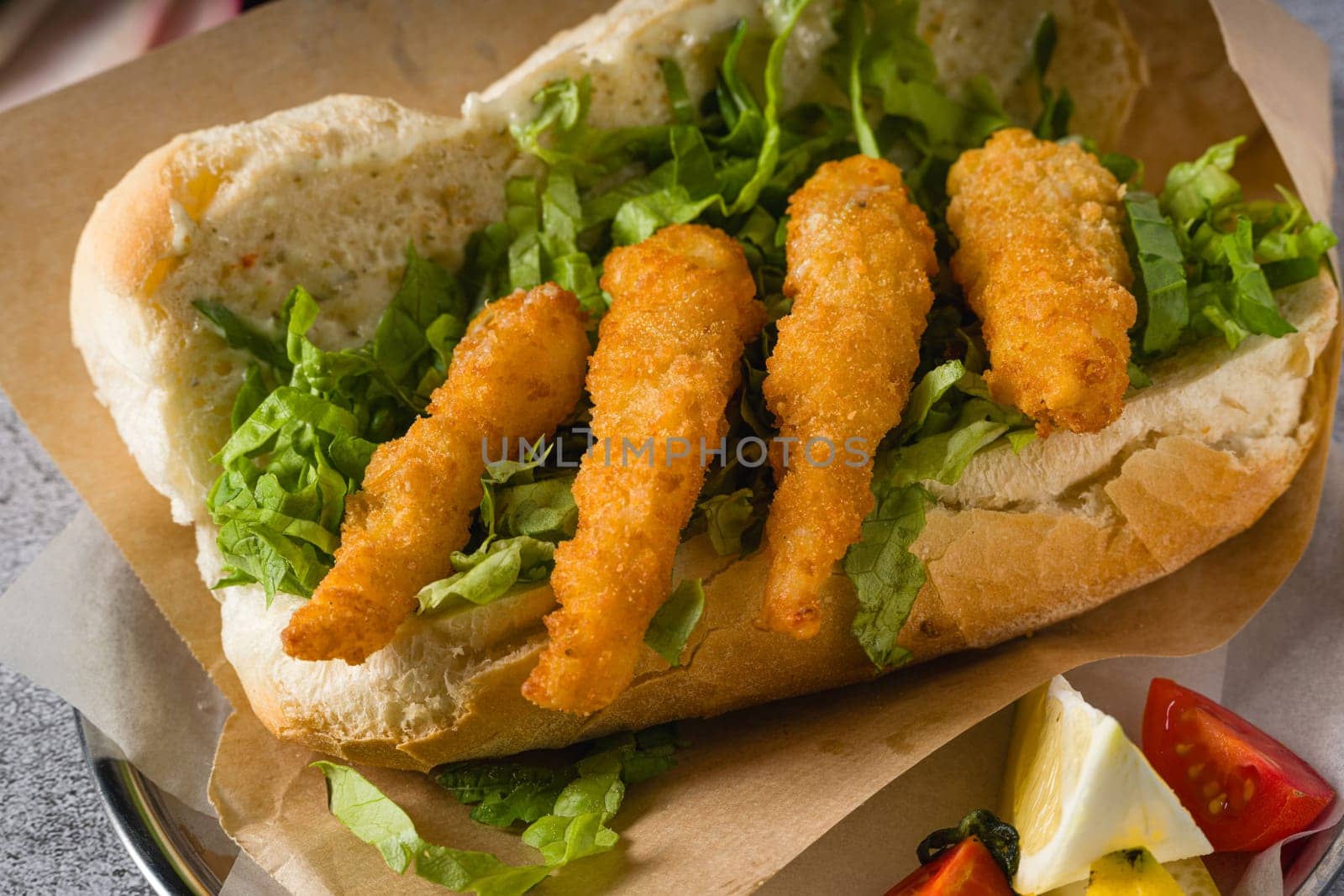 Deep fried shrimp in bread with greens on the side. Shrimp sandwich