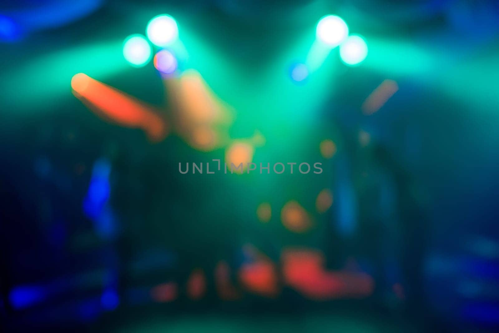 blurred abstract background of colored lights in night club with bokeh out focus and bright spots