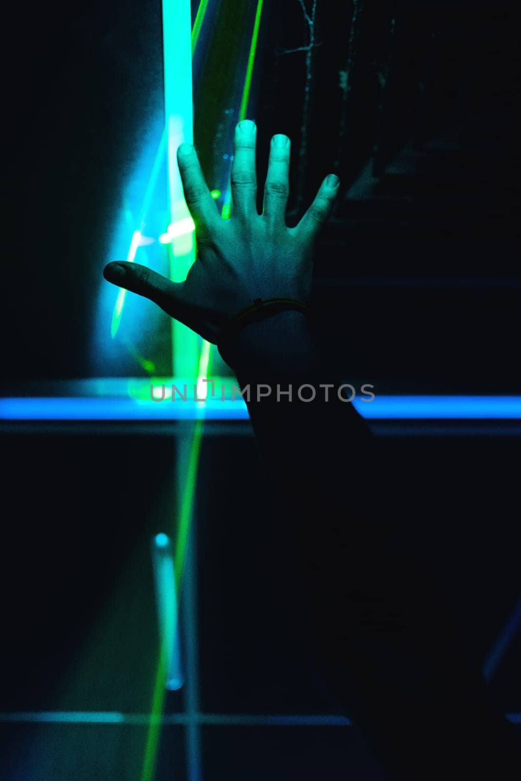 man's hand is raised up in a nightclub on a dark background