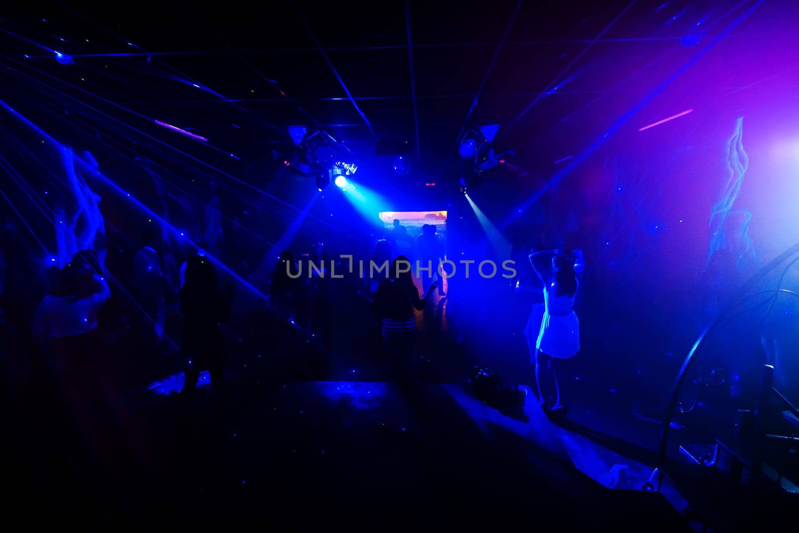 blurred silhouettes of dancing people at a nightclub party