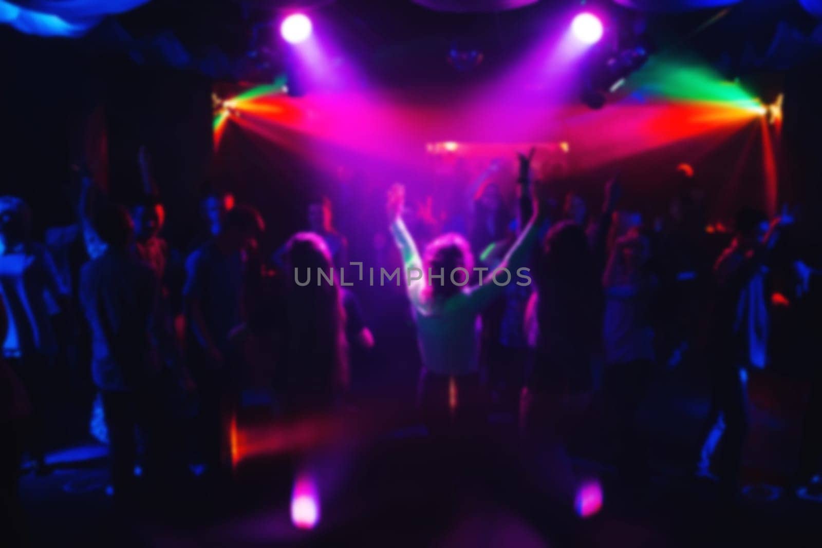 blurred silhouettes of dancing people at a concert with colored lights and spotlights