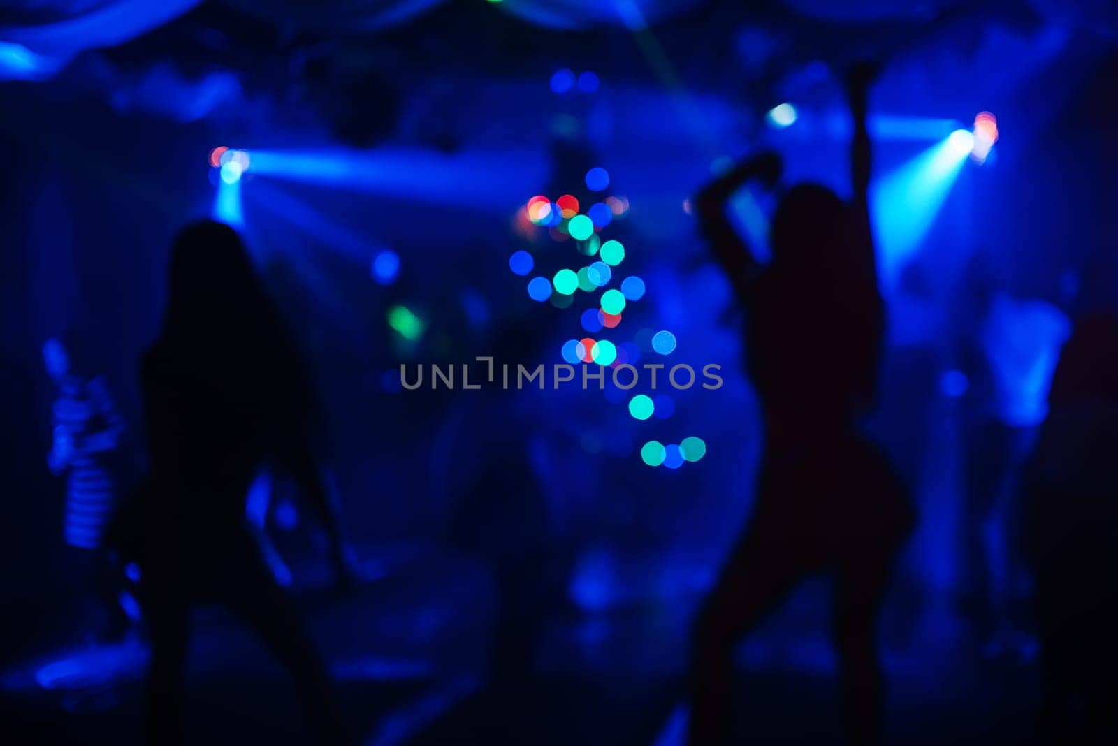 blurred silhouettes of dancing people at a nightclub party