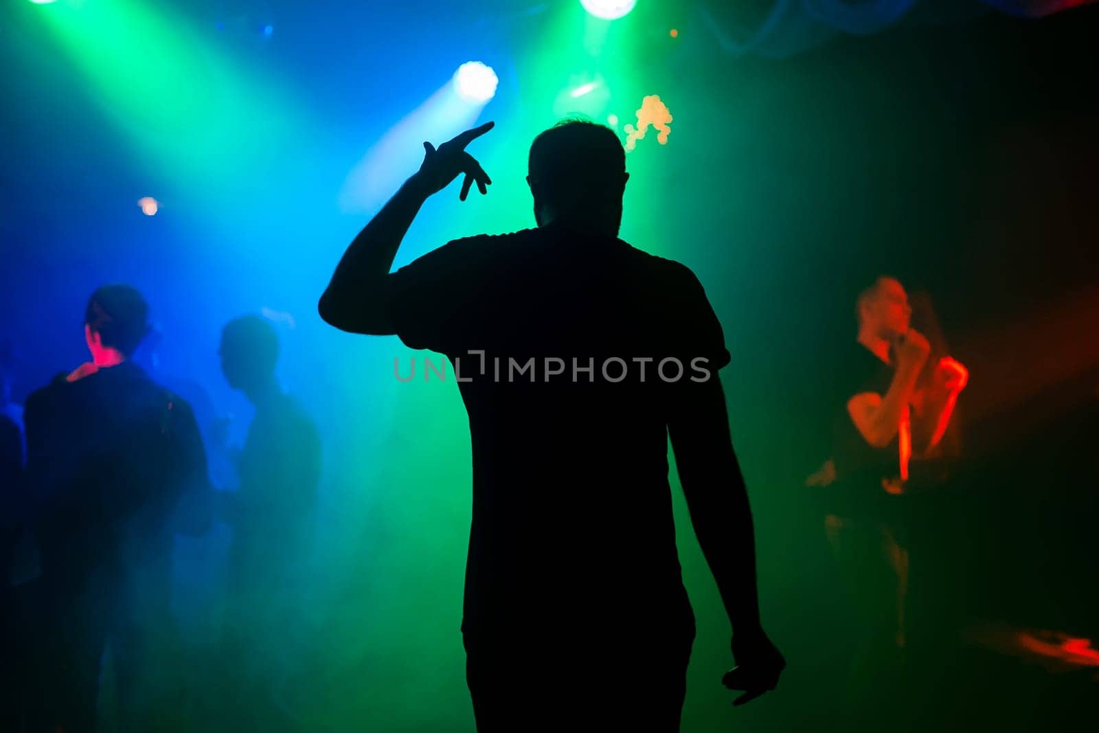 silhouette of the presenter on the night club stage at the concert back at the event