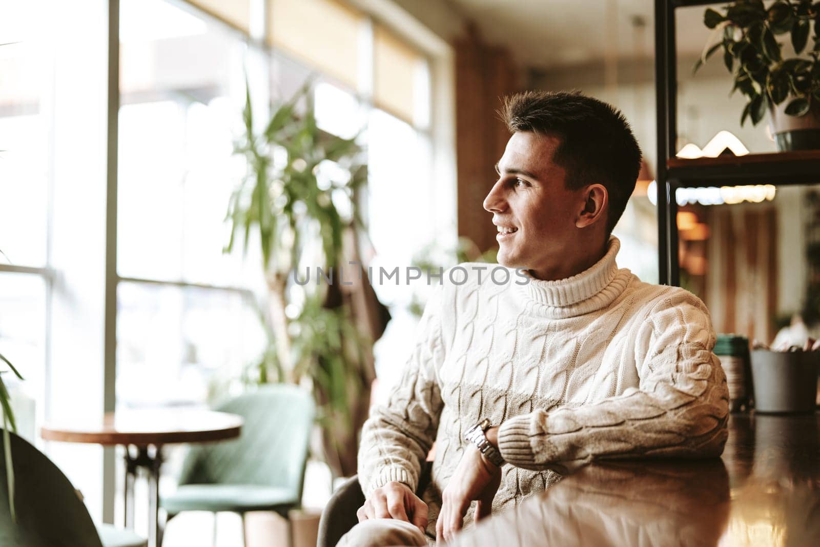 Man in White Sweater Sitting in Chair by Fabrikasimf