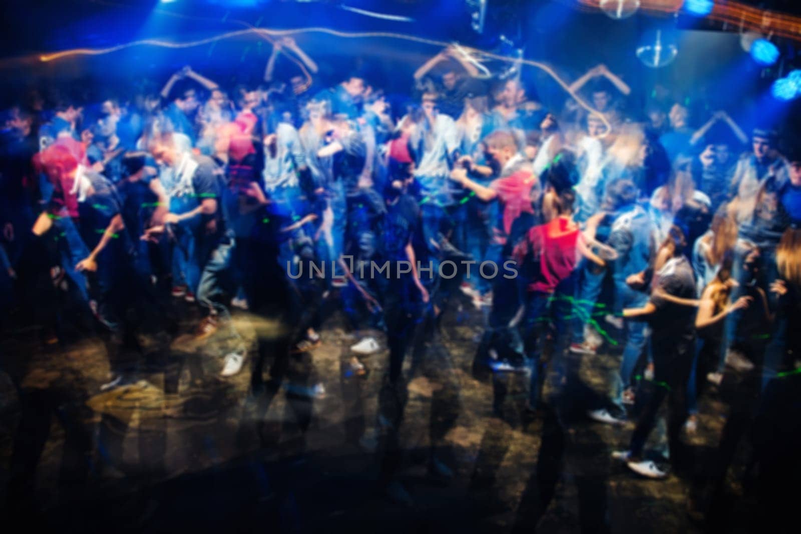 blurred abstract silhouettes of dancing people in night club with blurry effects