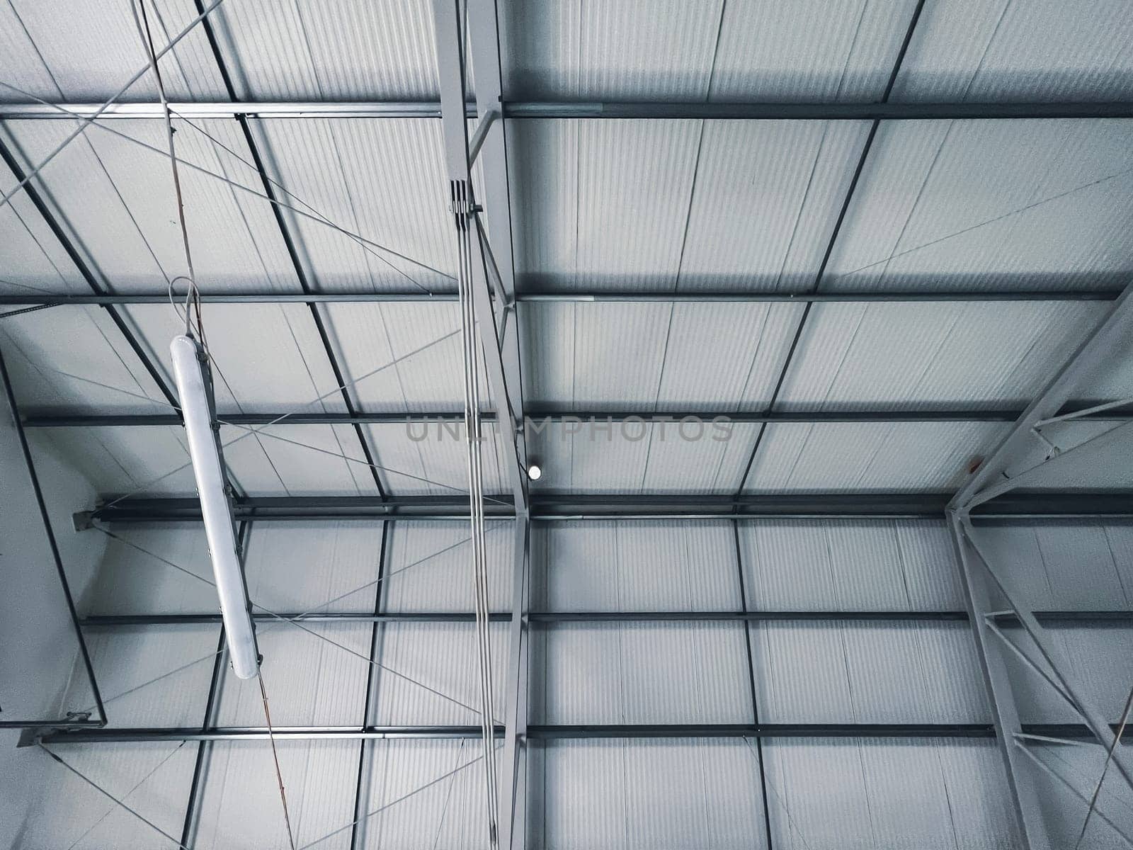 Building frame composition. Modern construction of industrial buildings. Hangar construction. Steel frame of the building with timber joists and sandwich panels on the roof