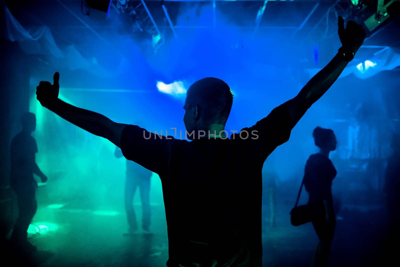 silhouette of a young leading on the dance floor of a nightclub with a blue smoky background