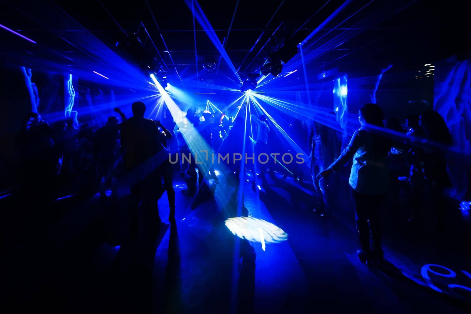 blurred silhouettes of dancing people at a nightclub party