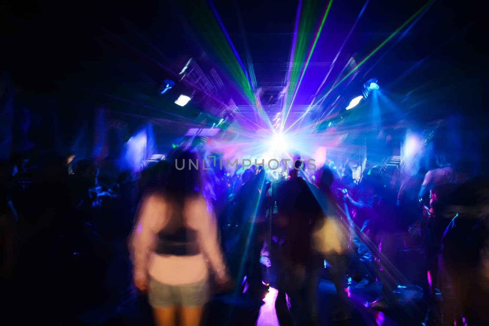 blurred silhouettes of dancing people at a nightclub party