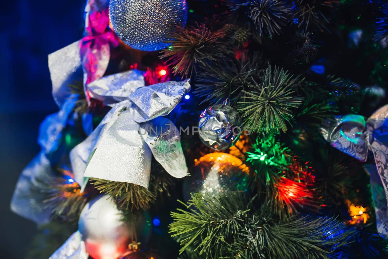 artificial Christmas tree decorated with toys, balls and bows blur