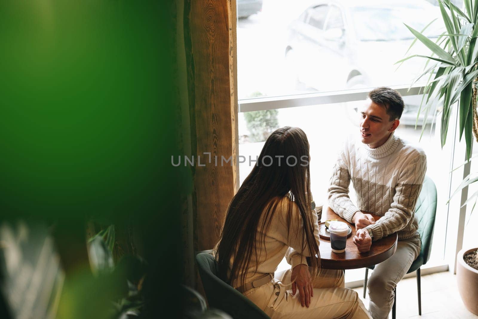Man and Woman Sitting at Table Talking by Fabrikasimf