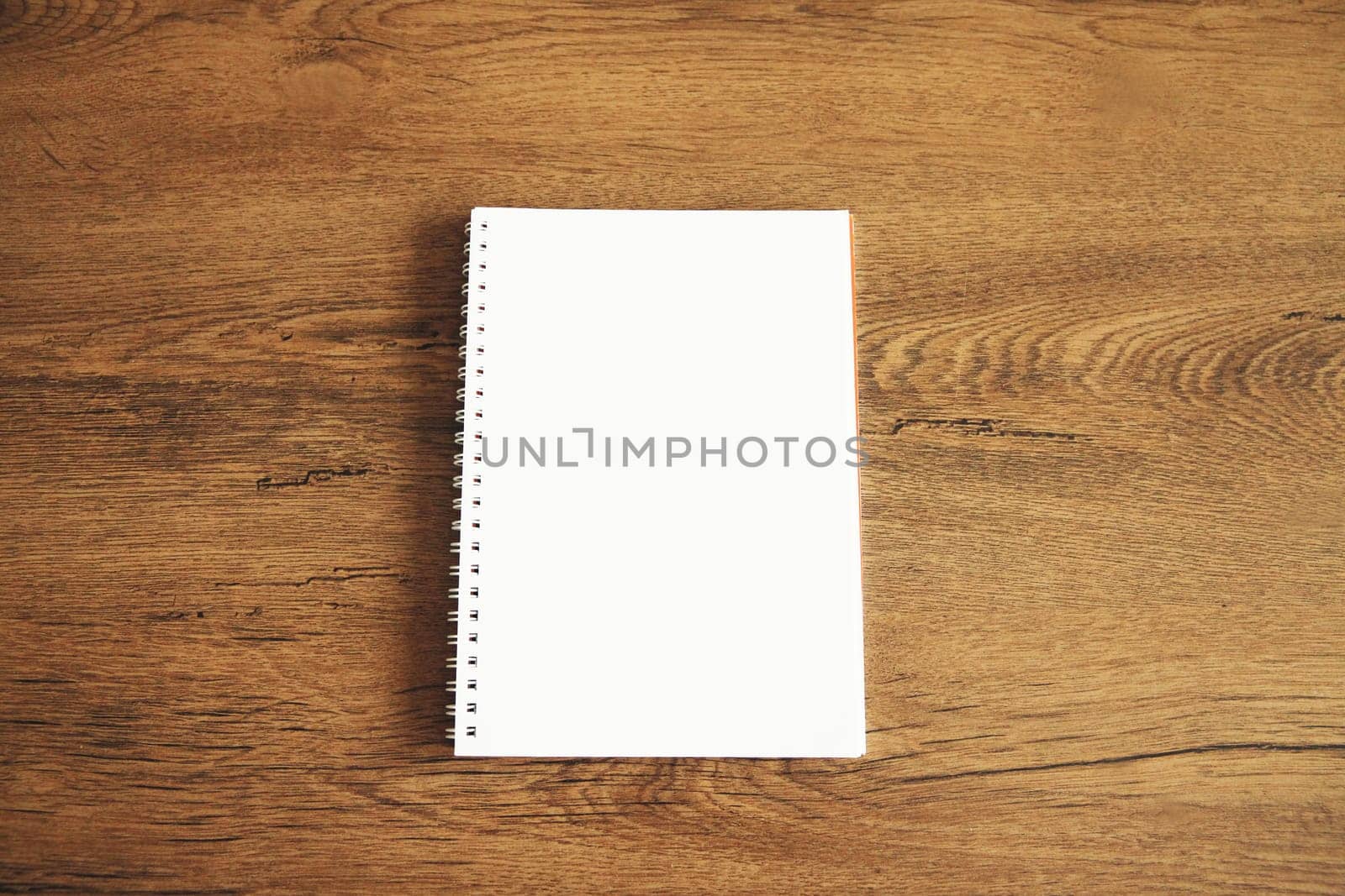 Top view of white blank notebook on wooden table by Rohappy