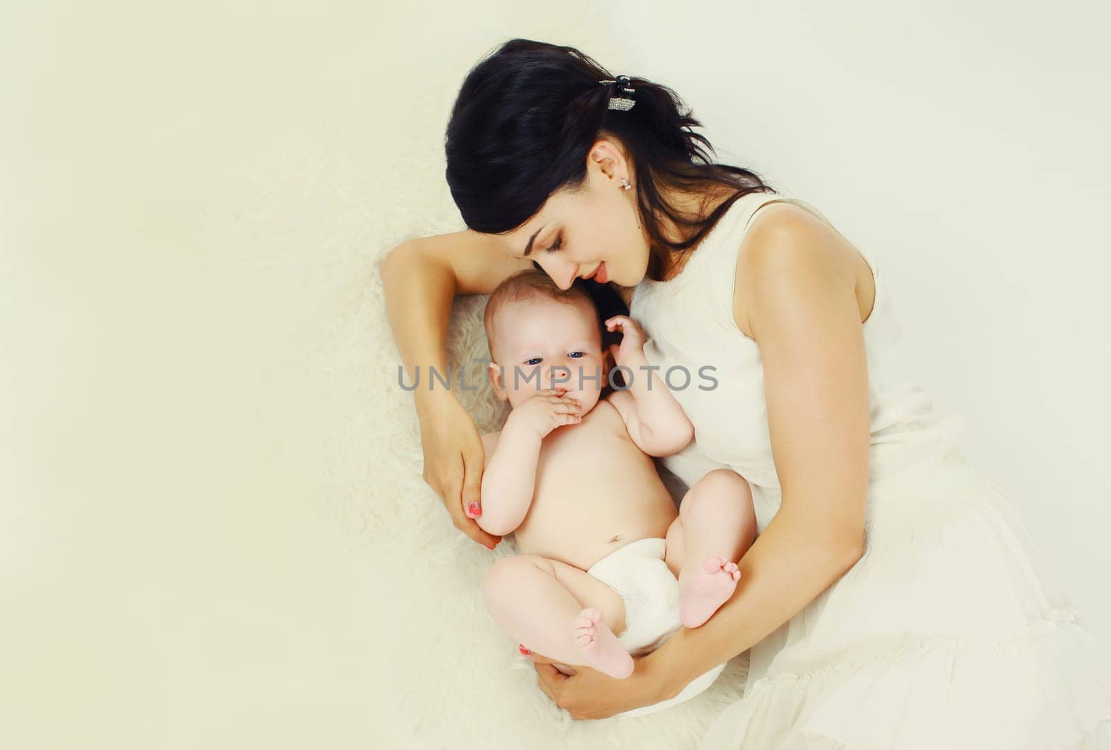 happy young mother lying with baby together at home by Rohappy