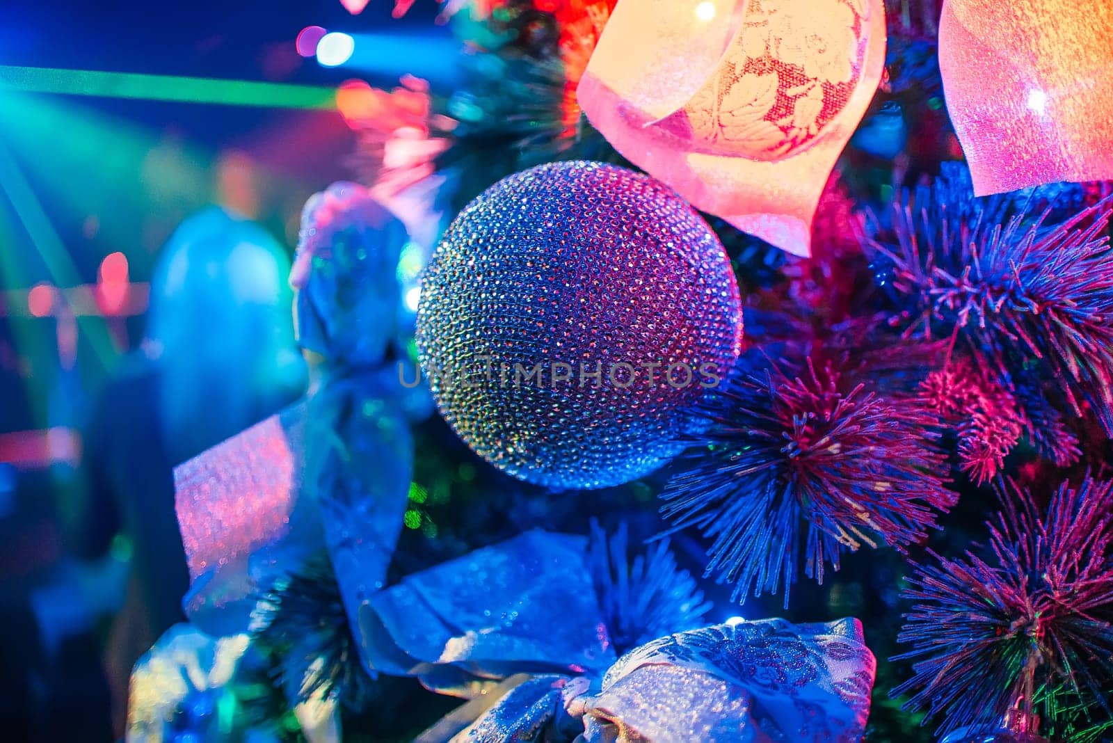 decorated bowl on the branches of a Christmas tree with bright colored lights
