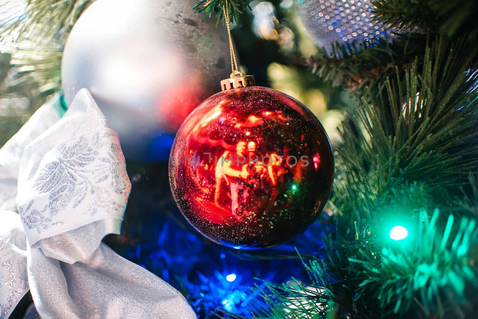 red ball on Christmas tree closeup close branches and reflection