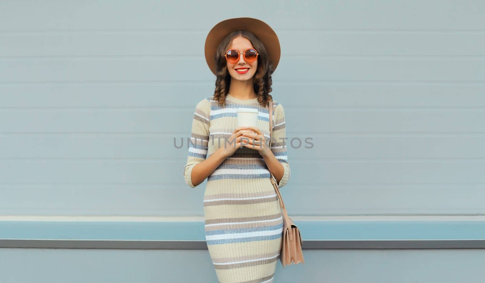 Stylish young woman posing in round hat, knitted dress, sunglasses by Rohappy