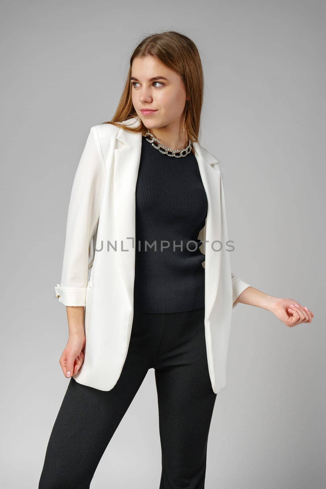 Woman in Black Top and White Jacket Posing in Studio by Fabrikasimf