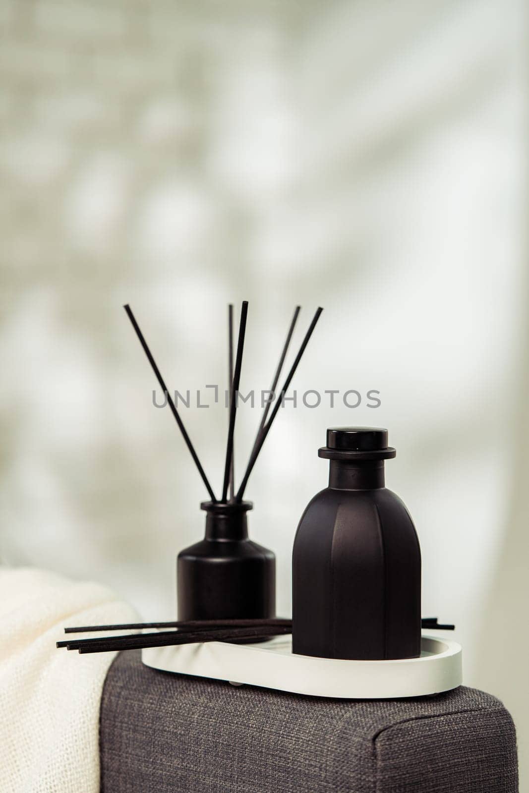 Aroma diffuser bottle with sticks in living room by Fabrikasimf