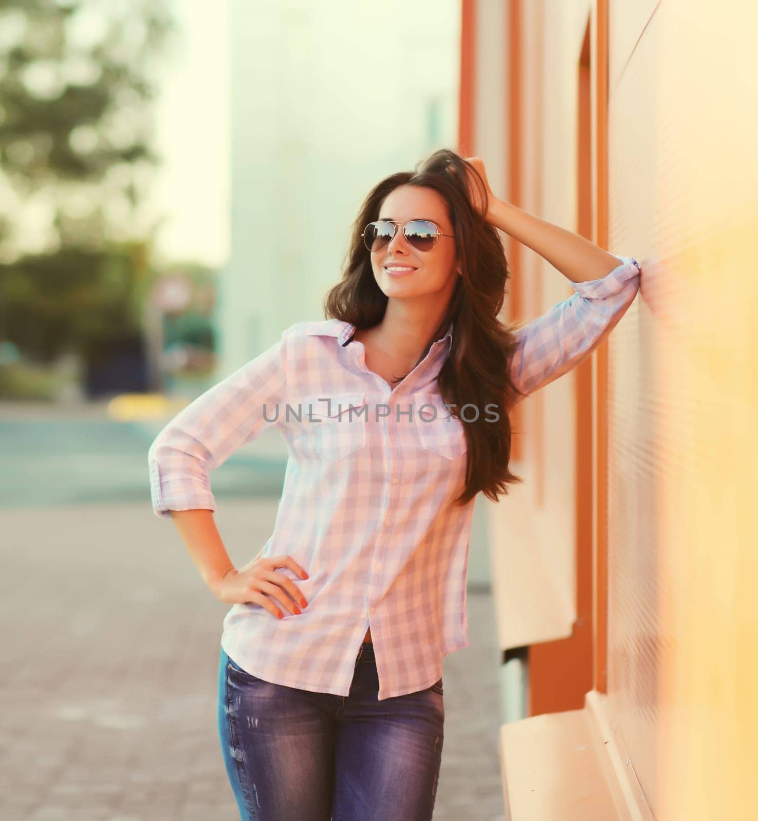 Portrait of beautiful happy smiling brunette young woman posing in the city