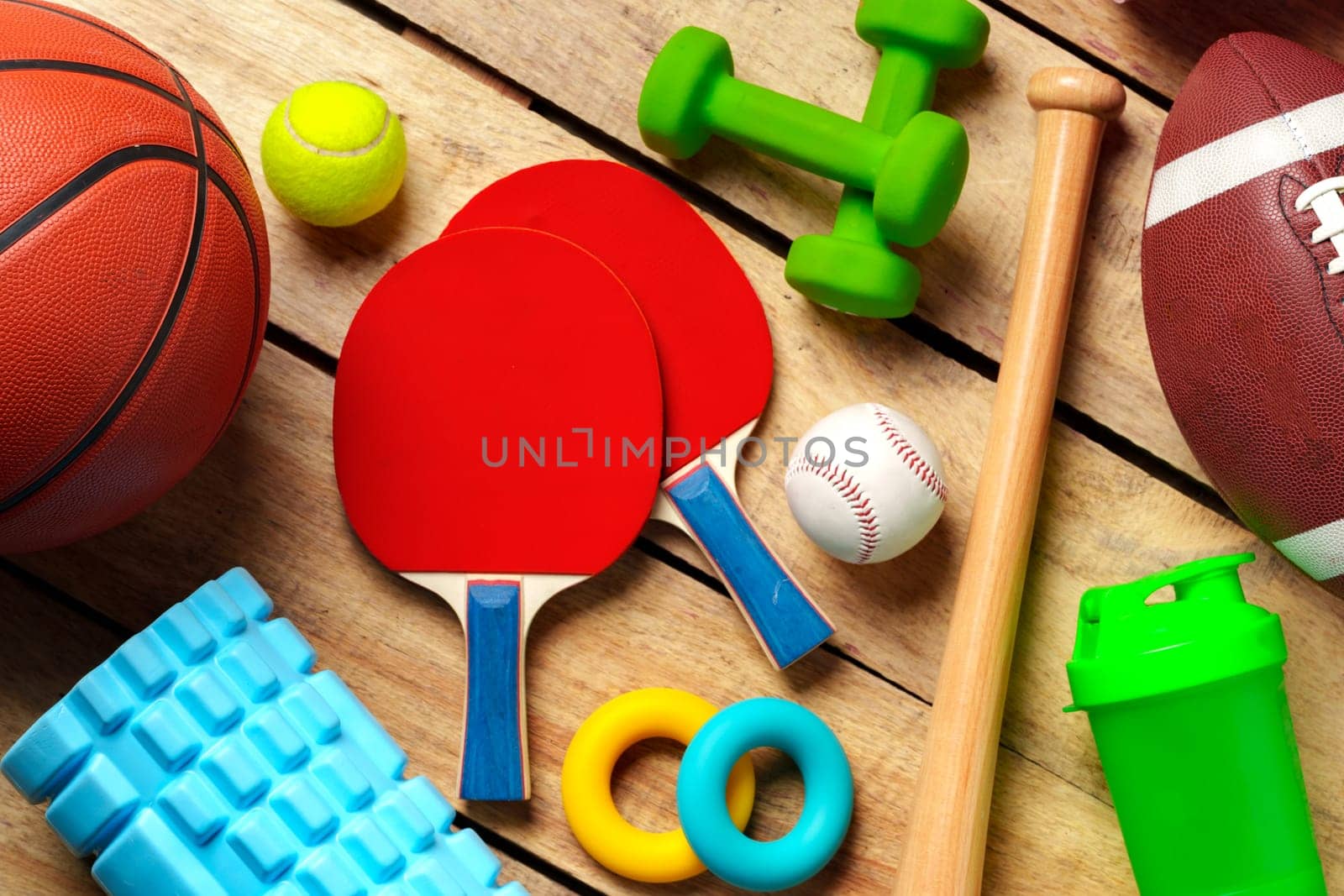 Different sports equipment on wooden background top view by Fabrikasimf