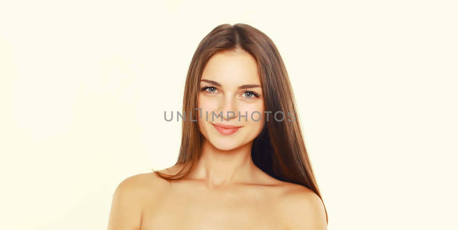 Beauty portrait of brunette smiling young woman on white studio background