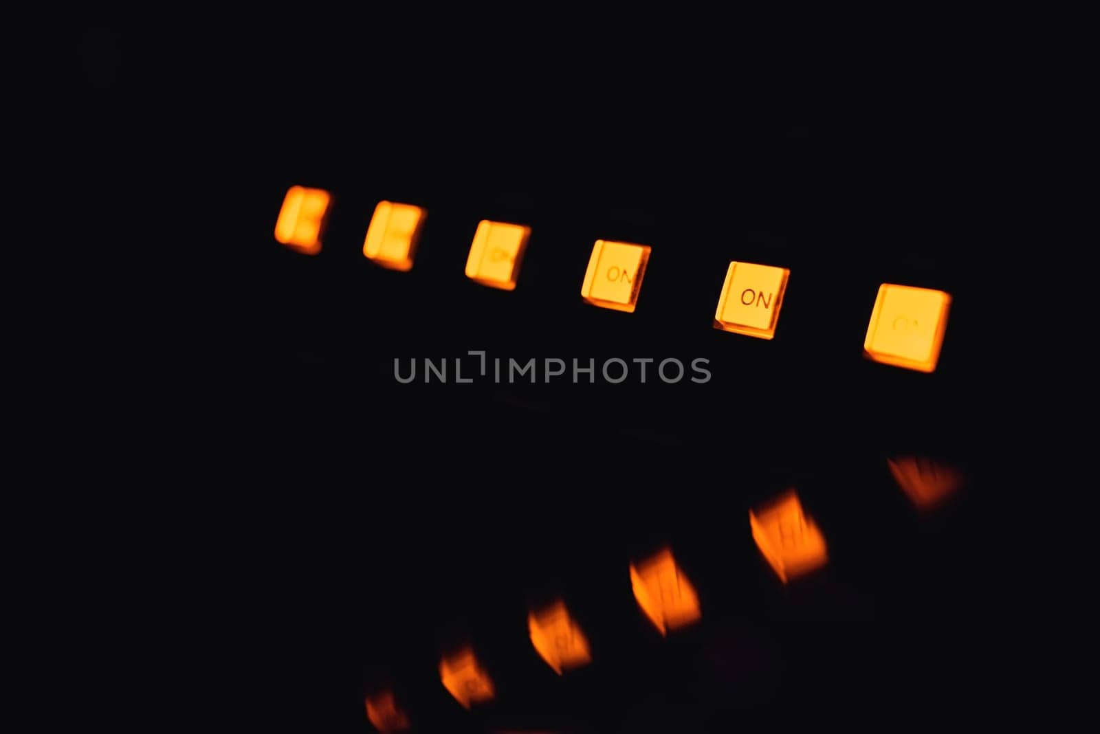 lot of yellow buttons power on musical equipment with reflection on black background