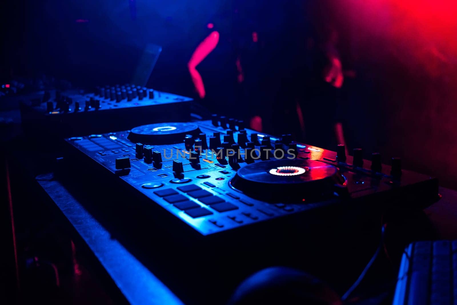 music mixer controller music control DJ under the light of spotlights in the booth at a nightclub